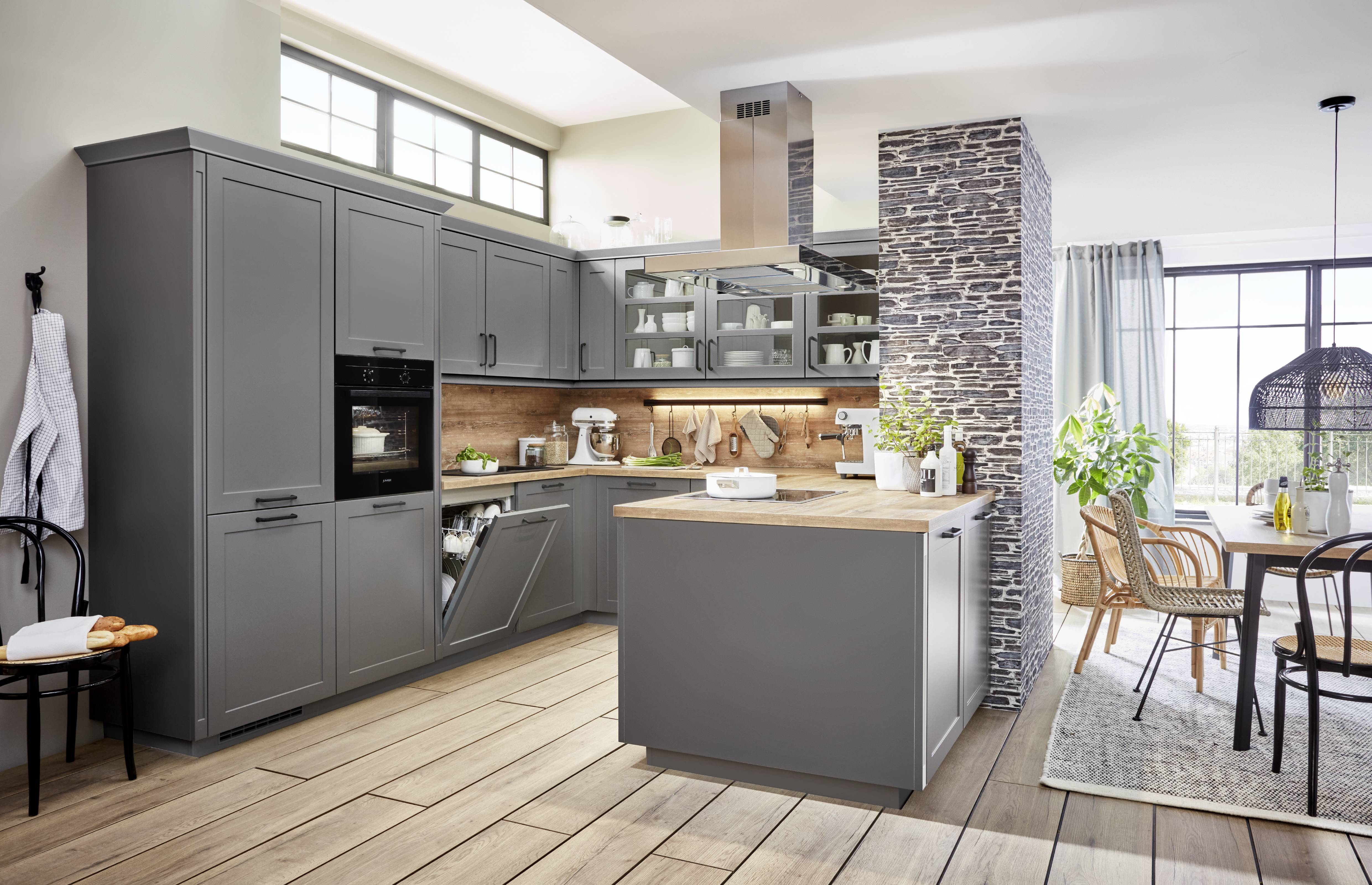 An open plan kitchen with deep grey cabinetry and a central island that supports everyday cooking and entertaining.