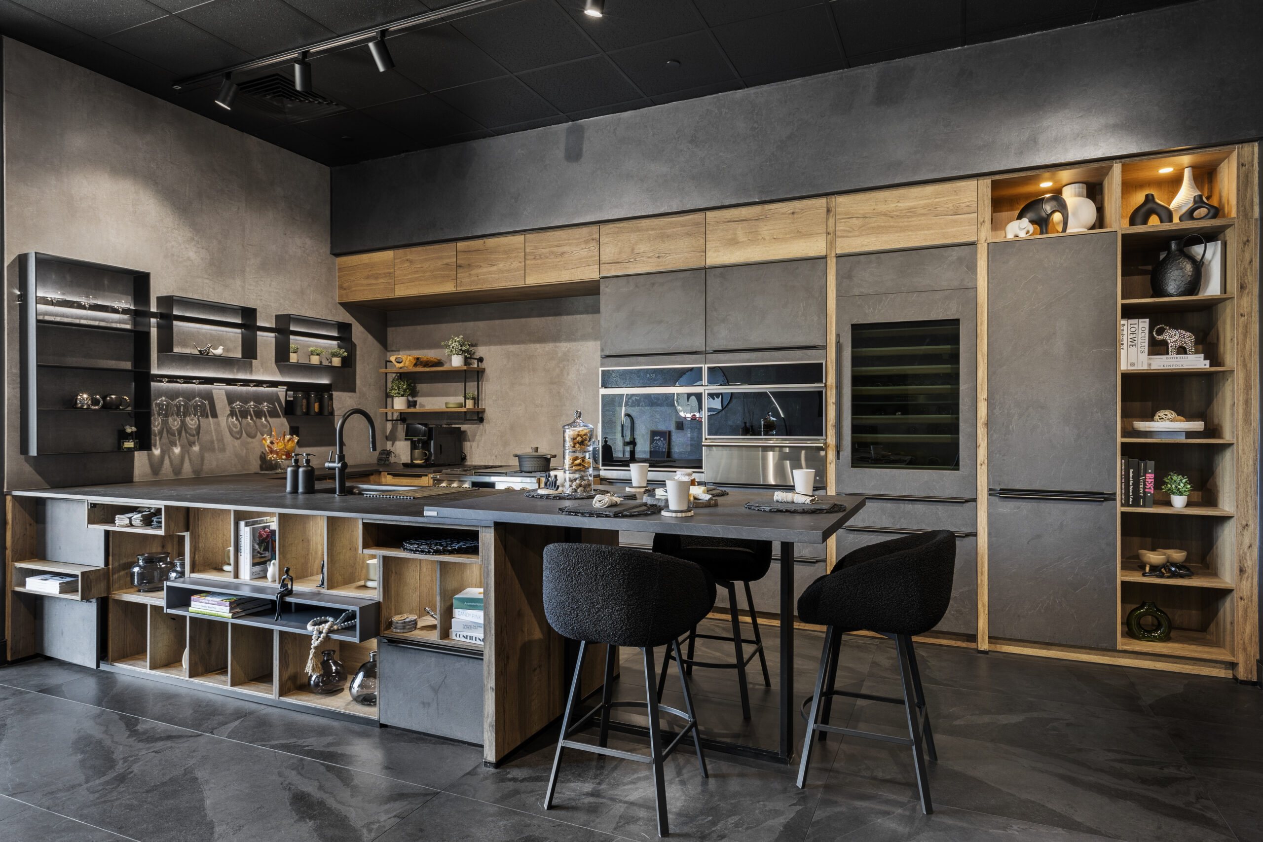 See it before you build it — a showroom consultation lets you experience the full scale of a design like this concrete-effect and raw oak kitchen before a single cabinet is ordered.
