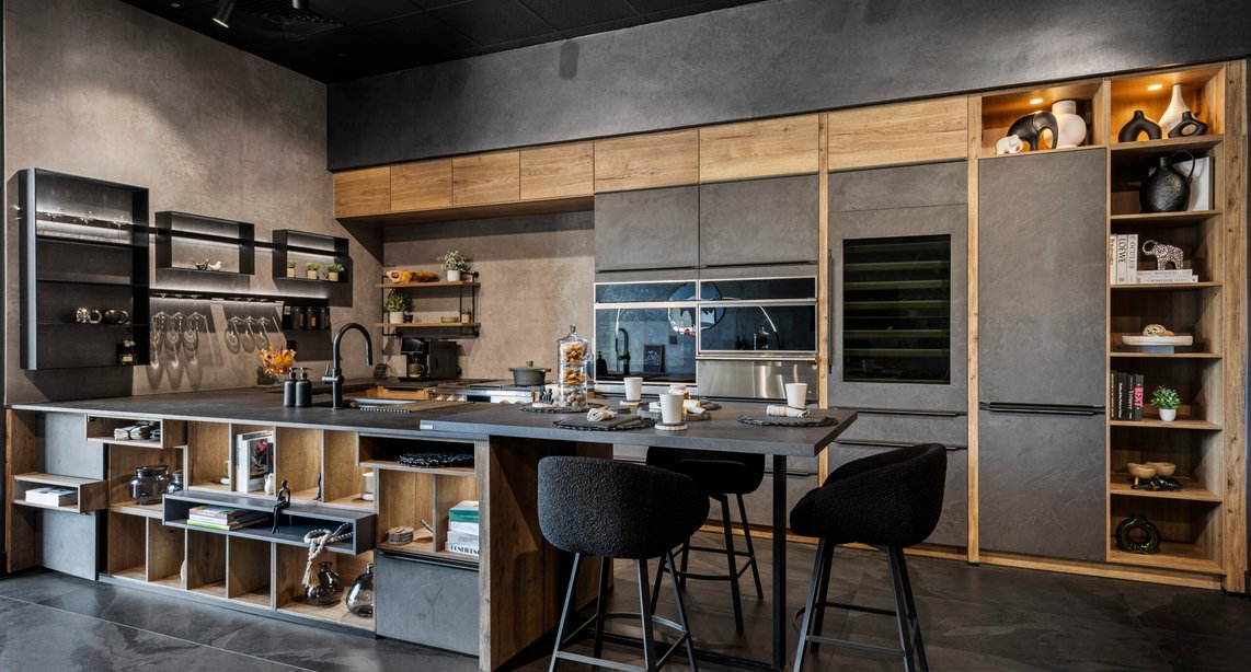 See it before you build it — a showroom consultation lets you experience the full scale of a design like this concrete-effect and raw oak kitchen before a single cabinet is ordered.